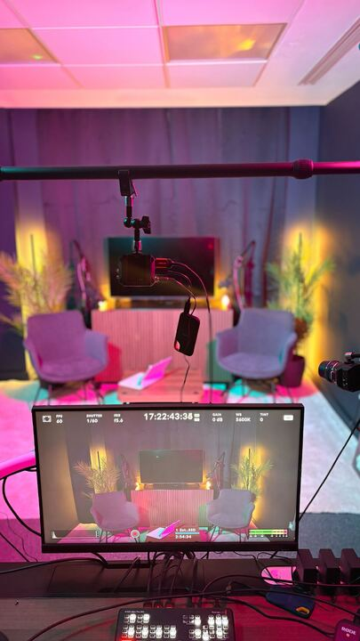 Behind-the-scenes production view with cameras and lighting